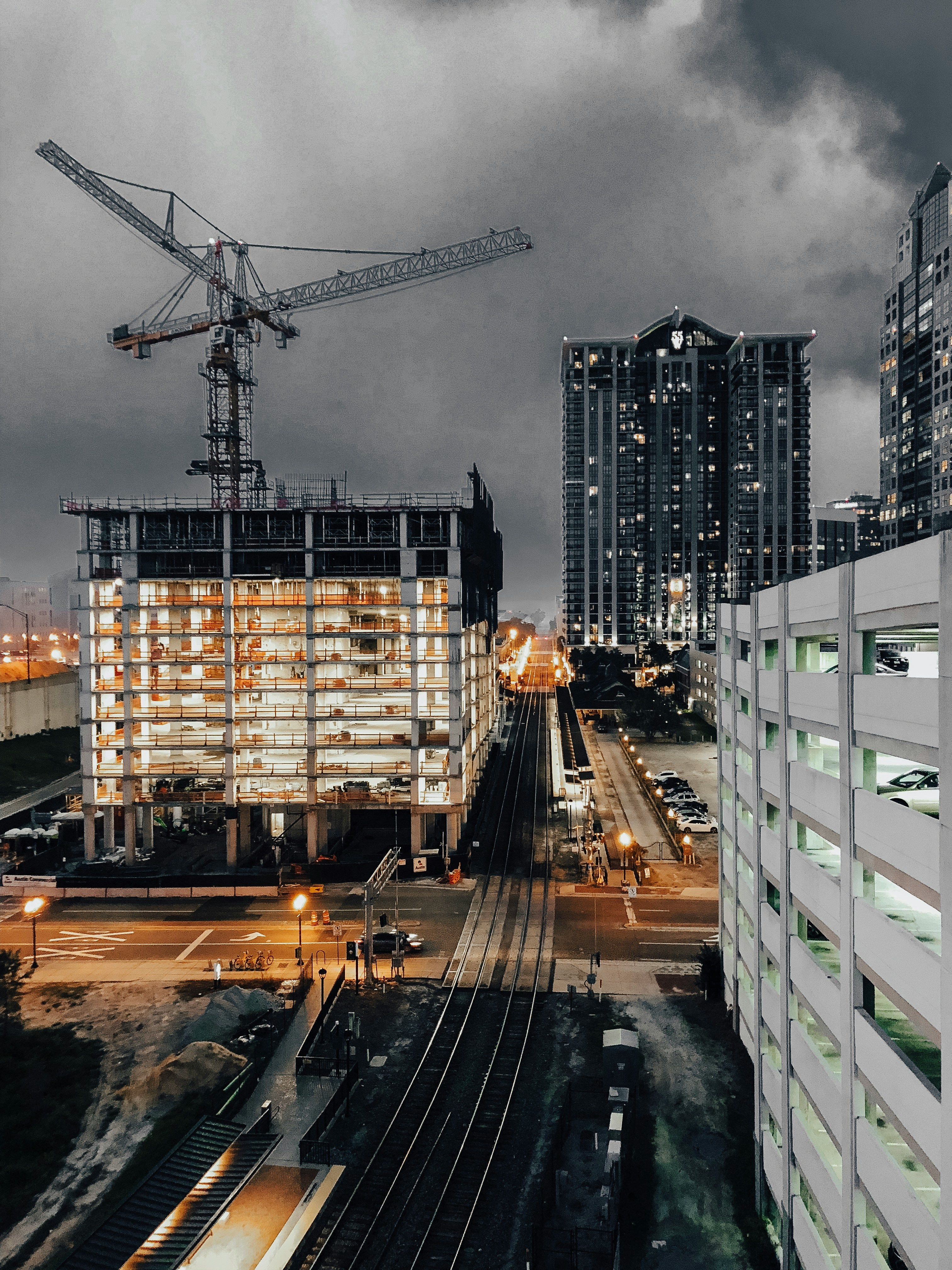 Urban construction tower coordinated beside completed buildings.